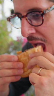 Sahilde sipariş edilen hamburgerin yarısını yiyen adam. .