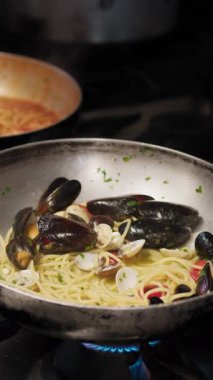 Şef, deniz ürünleriyle makarna pişirirken farklı tavalar kullanıyor.. 