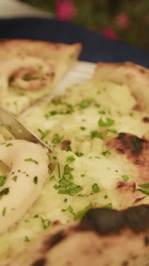 Adam çatal ve bıçakla gurme balık pizzasını kesiyor. . 