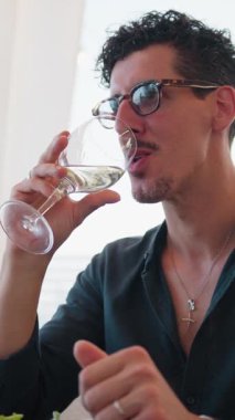 Plaj tatili sırasında arkadaşlarıyla tezahürat yapan ve içen bir adam..