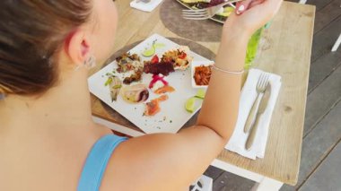 Kız lüks bir restoranda lezzetli bir balık tabağı yiyor..