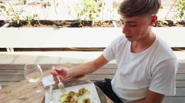 Genç adam, balık lokantasında Au Gratin ile öğle yemeği yiyor. . 