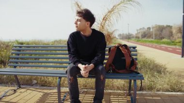 Doğadaki bankta oturan adam, havanın esintisini hissediyor ve dinleniyor. . 