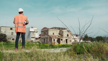 Doğa Mühendisi, yeniden inşa edilecek binayı inceliyor. . 