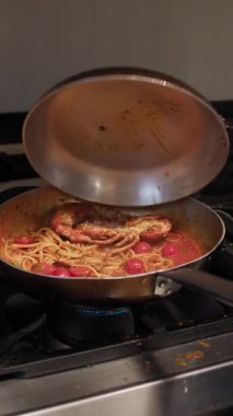 Şef, tabak hazırlığı için spagettiye ıstakoz koyuyor..