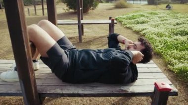 Açık hava parkındaki ahşap bankta adam trenleri var..