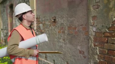 İnşaat alanının mimarı güvenlik için miğfere takıyor. . 