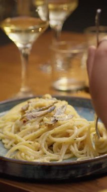 Yazın restoranda akşam yemeğinde spagetti yiyen bir kadın. . 