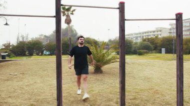  Spor salonunda barfiks çekerek antrenman yapan bir adam..