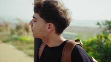 Denizin kenarındaki kaldırıma ulaşacak birini arayan yorgun bir adam. . 