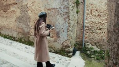 Eski kasaba sokaklarında ilham almak için eski bir kamera taşıyan kadın.. 