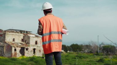 İnşaat işçisi proje belgelerini kontrol ediyor. .