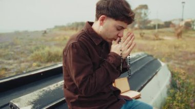 Adam kışın kıyıda tespih ve gözleriyle dua ediyor. . 