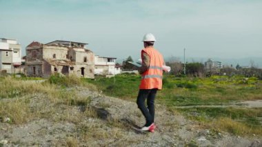 Mühendis, inşaatı yukarıdan izlemek için yüksek bir noktada yürüyor. .