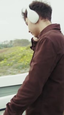 Sahildeki adam kulaklıkla müzik eşliğinde dans ediyor. . 