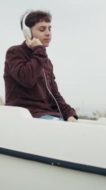 Adam kış boyunca sahilde bir teknenin içindeki müzikle dans ediyor. . 