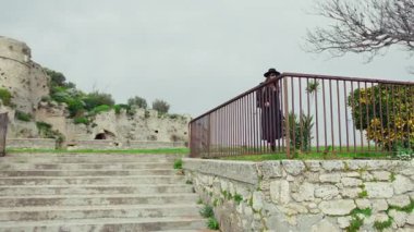 Ortaçağ Şatosu 'nun altındaki meydanda yürüyen ve dinlenen zarif kadın. . 