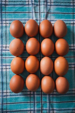 Mutfakta mavi bir masa örtüsü üzerinde 16 organik yumurta.