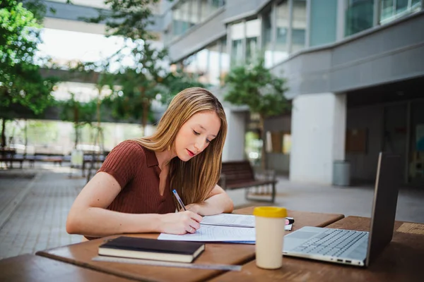 stock image Shot of student young woman studying by taking notes of the book. She is at the uni campus