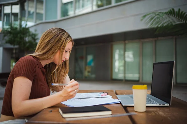 stock image Student girl reviewing her notes for the exam. She seems focus and she is at the uni campus.