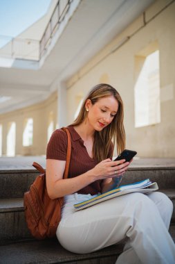 Üniversite kampüsündeki derslerden kaçarken akıllı telefonunu kullanan öğrenci kız.