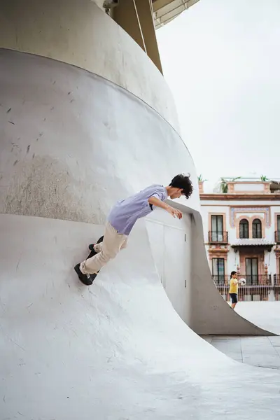 Jovem Subindo Uma Rampa Inclinada Concreto Com Seu Skate Cidade — Fotografia de Stock