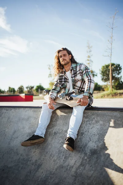 Portrét Mladého Muže Jak Dívá Kamery Zatímco Sedí Drží Skateboard — Stock fotografie