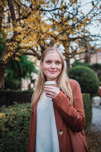 Портрет Усміхненої Молодої Жінки Тримає Чашку Кави Під Час Прогулянки — стокове фото