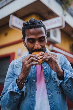 Sokakta çizburger yiyen bir gencin portresi. Hoşuna gidiyor..