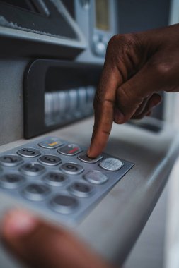 ATM klavyesini kullanarak bir elin yakın çekim görüntüsü. Banka hesabını kontrol ediyor..