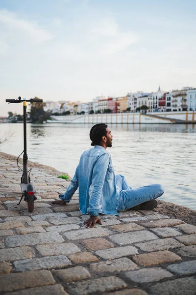Klidný Muž Sedící Zkříženýma Nohama Řeky Městě Blízko Elektrického Skútru — Stock fotografie