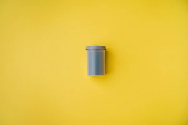 Stock image High angle view of film canister on yellow background. Film photography concept.