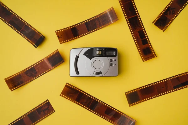 High angle view of point and shoot film camera on yellow background. Film photography concept.