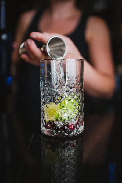 Donna Che Versa Rum Jigger Bicchiere Con Lime Bacche Fare — Foto Stock