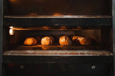 Endüstriyel bir fırında birkaç tane zanaatkâr ekmek pişiriliyor.