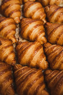 Bir zanaatkar fırınında arka arkaya yapılan pek çok yeni yapılmış kruvasanı kapatın.