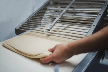 Anonim fırıncının eli otomatik olarak kruvasan hamuruna dokunuyor.