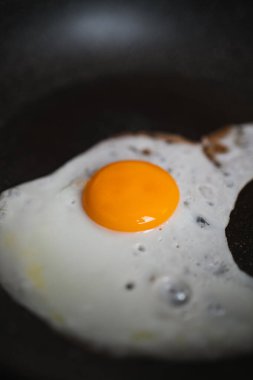 Tavada kızaran bir yumurtayı yakından çek. Kahvaltı konsepti.