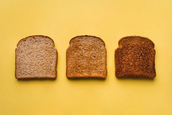 Τρεις Απομονωμένες Φρυγανισμένες Φέτες Ψωμιού Έχουν Διαφορετικούς Βαθμούς Ψησίματος Κίτρινο — Φωτογραφία Αρχείου