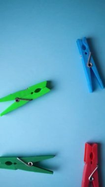 Mavi arka planda bir sürü farklı renkli mandalların üst görüntüsü. Çamaşır konsepti.