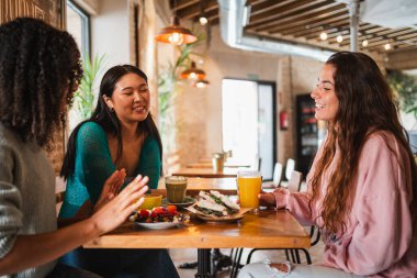 Bir grup arkadaş bir kafede brunch yemek üzereler..