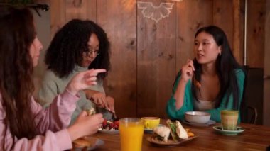 Bir grup arkadaş bir kafede brunch yerken eğleniyorlar.