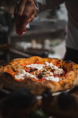 Aşçı İtalyan restoranında lezzetli bir pizza hazırlıyor.