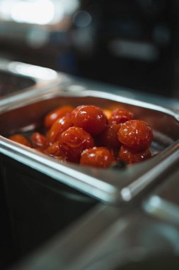 İtalyan restoranındaki metal kasede kiraz domateslerini yakın..
