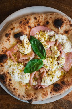 Otantik İtalyan pizzasının en iyi görüntüsü. İçinde mozarella, burrata, mortadella ve şam fıstığı var..