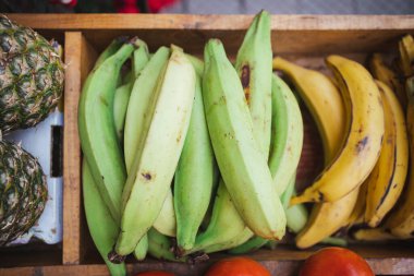 Şili 'de bir açık hava meyve dükkanındaki ahşap bir tezgahta olgun muz ya da ananas gibi farklı meyveler.