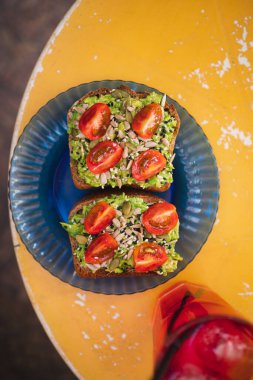 Avokado, vişneli domates, kabak tohumu ve susam tohumlu ekşi ekmek.