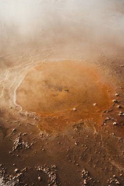 Şili 'nin Atakama çölündeki Tatio gayzerlerindeki küçük turuncu bir gayzerin yakın görüntüsü