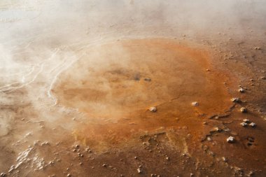 Şili 'nin Atakama çölündeki Tatio gayzerlerindeki küçük turuncu bir gayzerin yakın görüntüsü