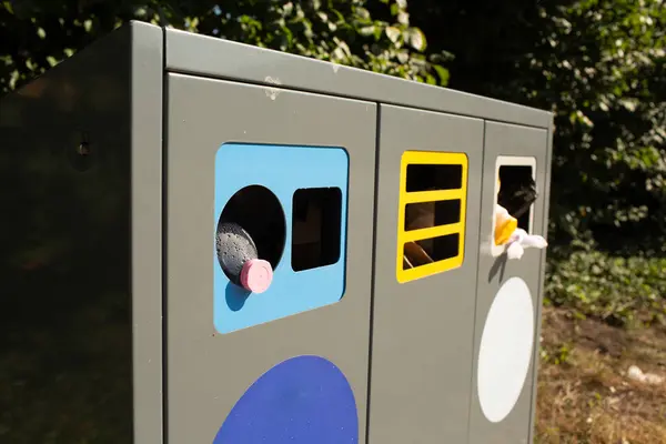 Bir geri dönüşüm kutusunun yakın çekimi plastik bölümü içine bir şişe yerleştirilmiş olarak gösteriyor. Atık ayıklama ve geri dönüşüm farkındalığını teşvik eder.